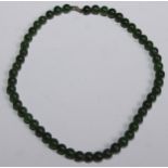 A Chinese jade bead necklace, 40cm long