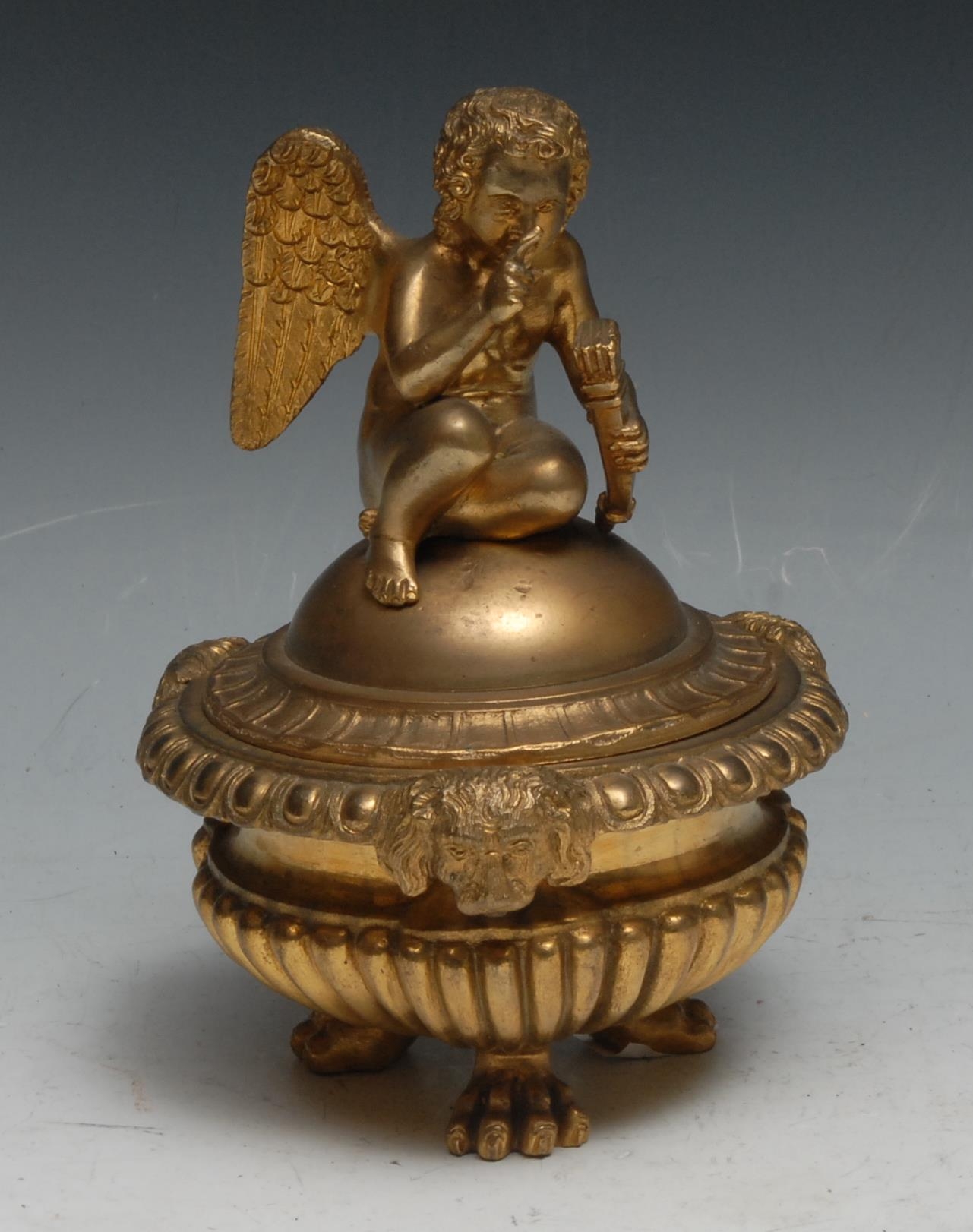 A Regency design gilt bronze half-fluted tripod inkwell, domed cover crested by a putto, egg-and-