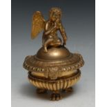 A Regency design gilt bronze half-fluted tripod inkwell, domed cover crested by a putto, egg-and-