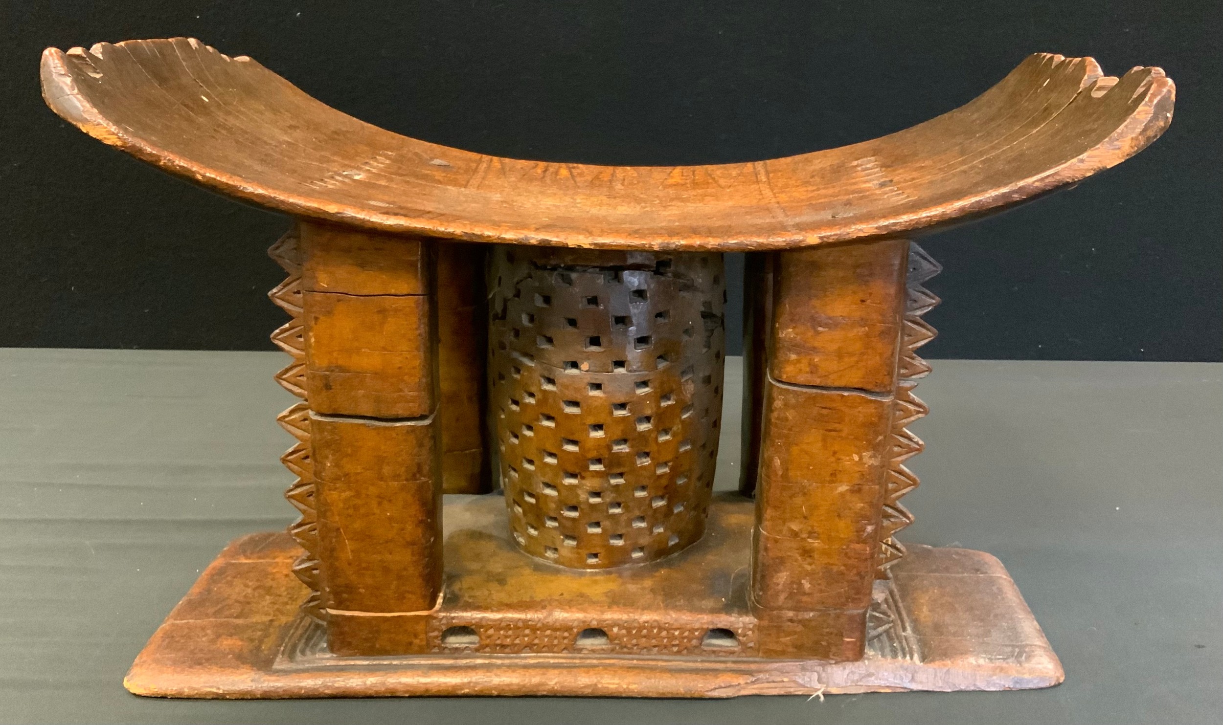 Tribal Art - a 19th century Ashanti stool or seat, arched rectangular seat with four carved supports