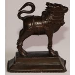 An Indian brown patinated bronze figure, of a Nandi bull, spreading rectangular base, 10cm high,