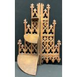 A Gothic Revival oak three-tier corner waterfall wall shelf, pierced and carved with foliate