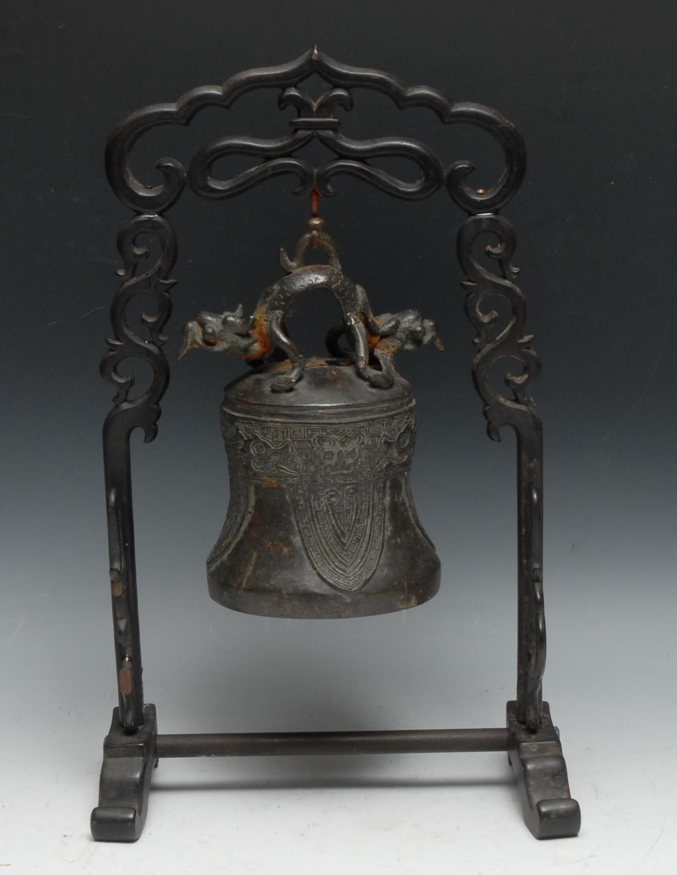 A Chinese bronze bell or gong, cast in the typical Archaic taste with dragons, lappets and taotie,