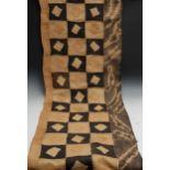 A Kuba Congolese woven panel, alternating black and cream geometric panels, approx 324cm long,