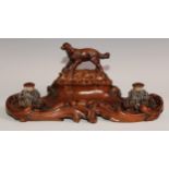 A 19th century walnut desk stand, carved in the Black Forest manner, the central compartment