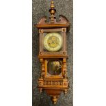 A German walnut wall clock, Roman numerals, twin winding holes, the case with spire finial, glazed