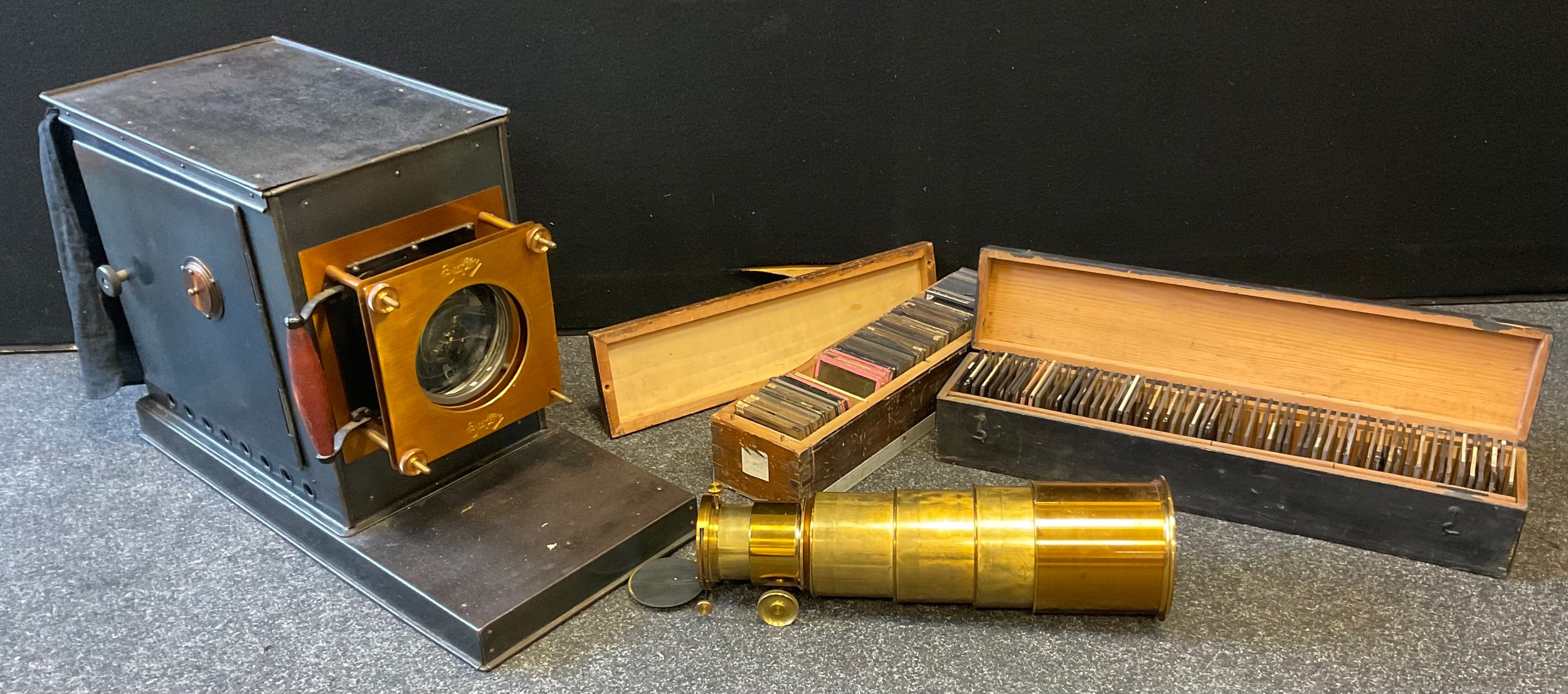 A late Victorian lacquered brass and black painted magic lantern, c.1890; two boxes of slides,