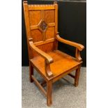 A mid 20th century Pitch pine Wainscot chair, four-panel back, carved plaque to centre with initials