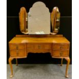 An Art Deco style walnut dressing table, triple mirrored back, above an arrangement of five drawers,