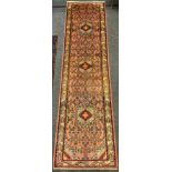 A Rudbar Runner carpet, hand knotted in soft tones of red, pink, cream, and blue, with a row of