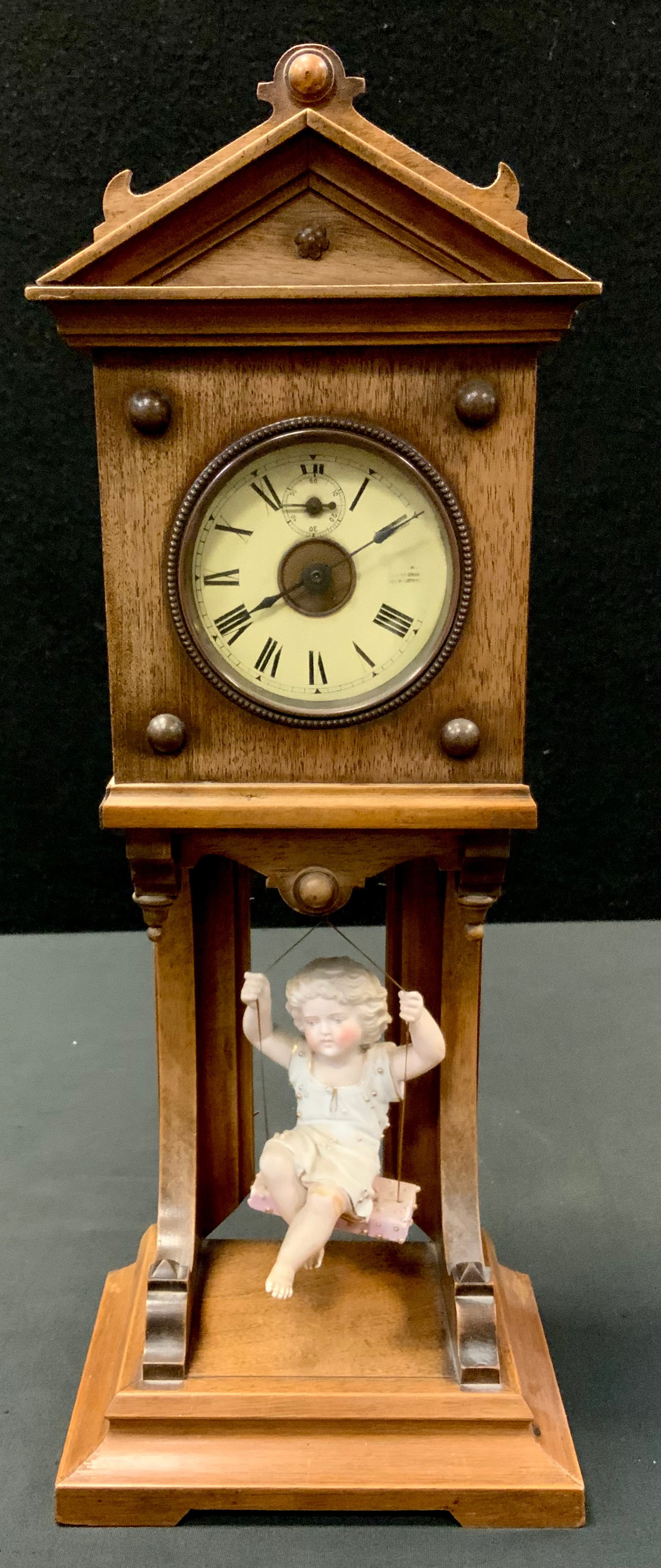 A 19th century German mantel clock, Roman numerals, the case architectural pediment, the pendulum
