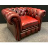 A Chesterfield Club chair, deep button back, scroll arms, Sang de Bouef red leather, 67cm tall (43cm