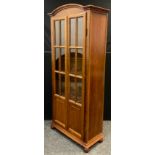 A 20th century mahogany bookcase cabinet, pair of glazed doors enclosing four tiers of shelving, bun