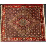 A Senneh rug / carpet, knotted in red, burgundy, coral, and deep indigo, with a hexagonal