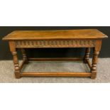 A 19th century oak long stool, rectangular over-sailing top, cut detailing, carved frieze, turned
