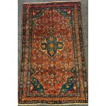 A Farahan rug / carpet, hand knotted in deep shades of red and blue with quatrefoil medallion in a