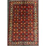 A mid 20th century Persian Veramin rug / carpet, hand-knotted in rich red, with a field of blue,