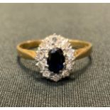 A sapphire and diamond cluster ring, central deep blue oval sapphire approx 0.40ct, ten diamonds,