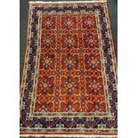 A Persian Mashad hand-knotted rug / carpet, having a central field in rich red and Lapis blue,