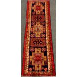 An Azerbaijan runner carpet, hand-knotted in red, cream, and deep blue, 332cm x 109cm.