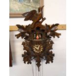 Black forest style cuckoo clock with cuckoo and people appearing on chime