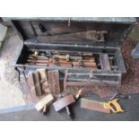 A vintage tool chest containing wooden moulding planes, marking gauge, saw etc