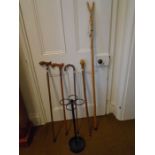Metal stick stand with 4 walking sticks - one with carved fish handle and a thumb stick (5)