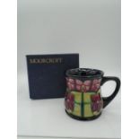 Moorcroft pottery mug in the Violet pattern (red and pink), of waisted form, designed by Sally