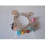 A Tiffany &Co sterling silver charm bracelet with 'Return to Tiffany' heart tag and 9 charms. -