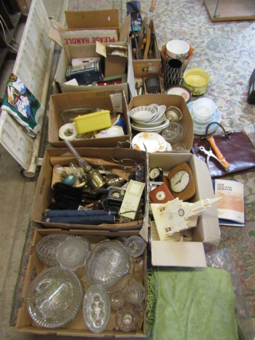 A stillage of mixed items to include china, glassware, kitchenalia, tools, leather bag, clocks,