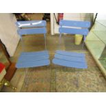 2 blue metal folding chairs