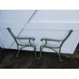Pair of painted cast iron garden bench ends with wooden arm rests