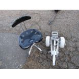 chrome and black swivel chair and a golf trolley