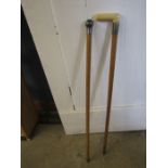 2 walking canes, one with metal top and one with a bone handle and metal collar