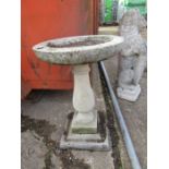 A concrete bird bath 27" high