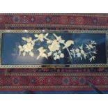 An Oriental wooden panel with painted 'shell' birds and flowers