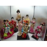 A collection of Modern Oriental dolls on wooden stands