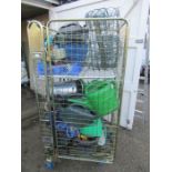 Stillage containing garden items and tools including watering cans, workbench, hosepipe and