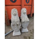 A pair of concrete lions bearing a shield, one is broken in half but sits together 33" tall