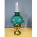 Brass base oil lamp with dark green glass shade and a spare funnel