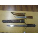 2 Wooden handled knives in wooden sheaths. Largest L52cm approx