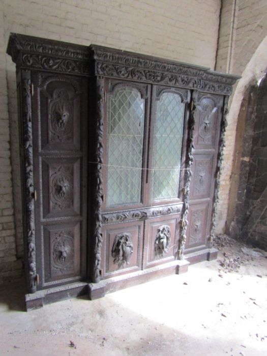 Carved oak Hunters cabinet with 2 central leaded glass doors above 2 door cupboard, flanked by