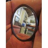 Mahogany veneered oval bevelled wall mirror