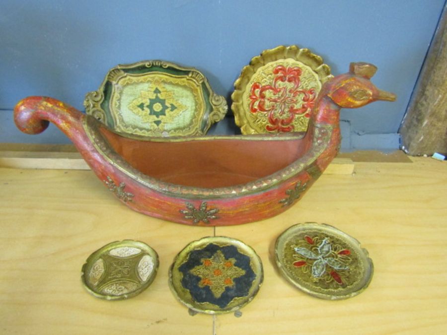 A treen long boat depicting a bird with a selection of plates in a silmilar style
