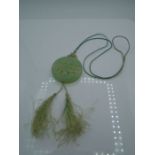 Chinese carved "jade" double sided pendant necklace on green thread with tassel end