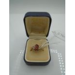 yellow gold ring set with red stone and miniature pearls stamped 9ct, gross weight 2.2g