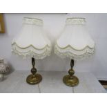 A pair of brass based lamps with shades