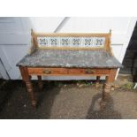 A pine washstand with marble top and tiled back