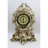 A Porcelain Mantle Clock decorated with Applied Bocage Flower and Cherubs Raised on Scrolled Feet
