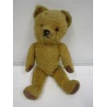 A vintage teddy bear with moveable arms and legs